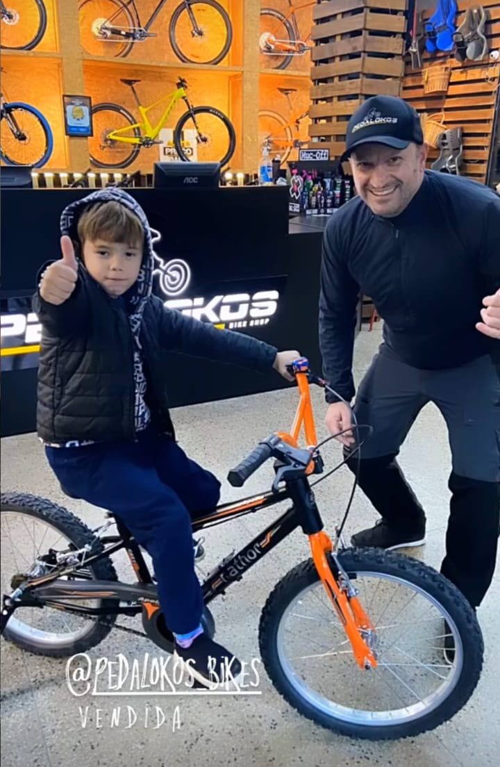 Criança com sua primeira bicicleta aro 20 laranja na Pedalokos